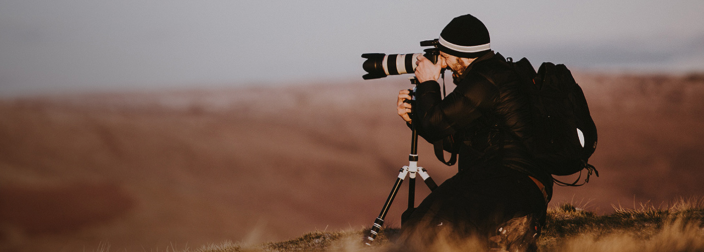 A man capturing a photograph on the hill